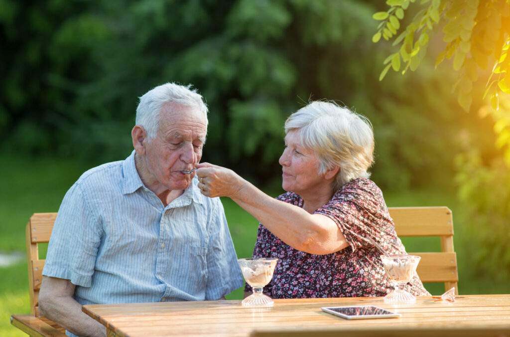 Old couple eating ice cream outside